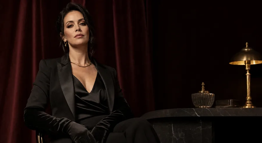 Confident adult Findomme in tailored black representing a calm financial-dominant role